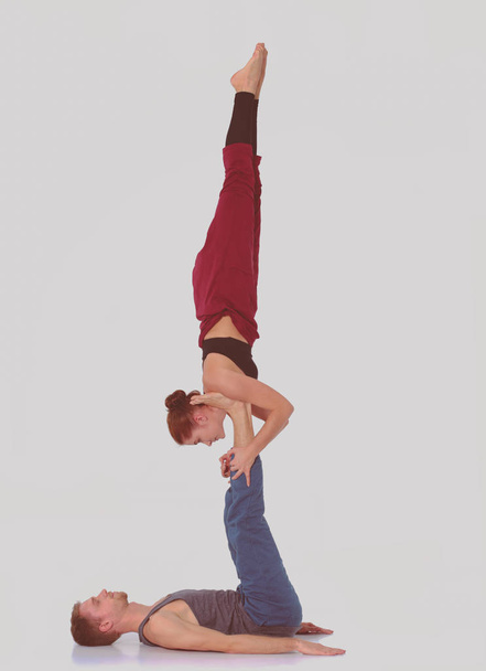 Young athletic couple practicing acroyoga. Balancing in pair. - Foto, immagini