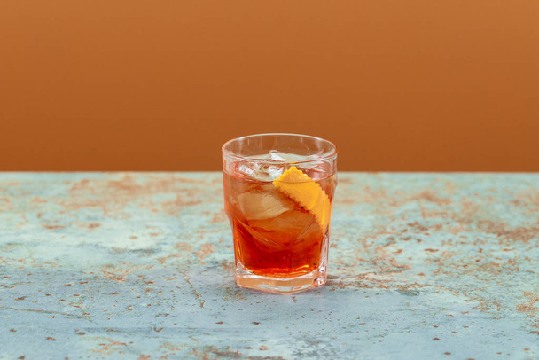 Negroni cocktail with lemon and ice in Old Fashioned glass - Fotografie, Obrázek