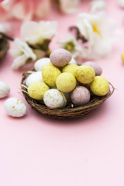 Easter eggs in the nest on pink background. Spring greeting card with copy space. - Photo, image