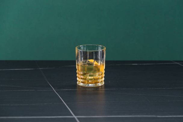 gelbe Farbe Whisky mit Zitronenscheibe und Eis  - Foto, Bild
