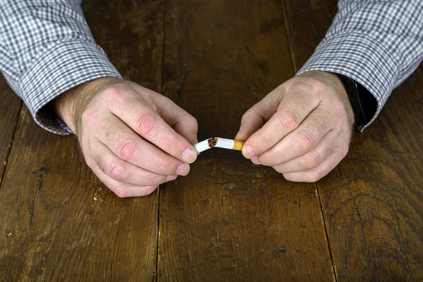 Broken cigarette with a filter in hand - Foto, imagen