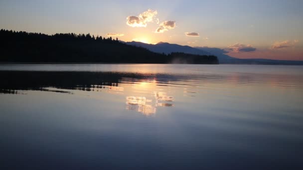 wunderschöne Landschaft mit Bergen und See im Morgengrauen in goldenen, blauen und violetten Tönen. - Filmmaterial, Video