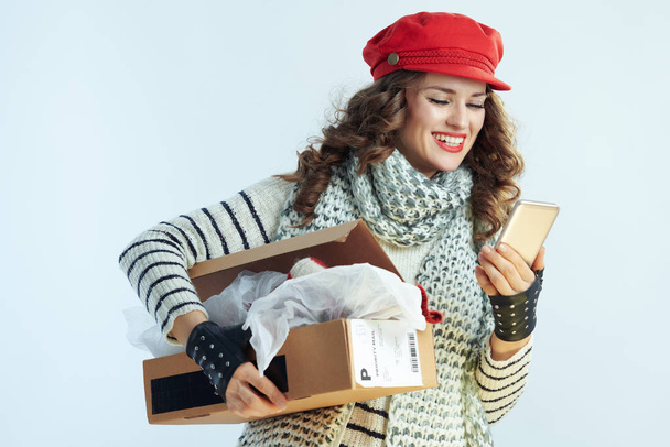 happy elegant woman holding opened parcel and app - Foto, imagen
