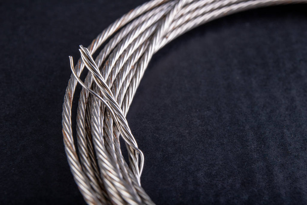 Steel rope coiled in a loop. Accessories in a home workshop.  - 写真・画像