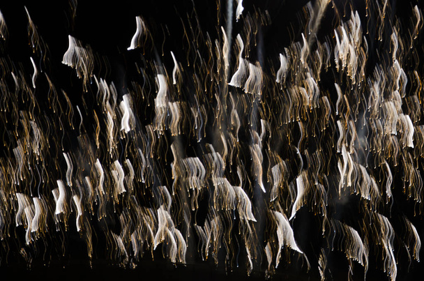 Spektakuläres Feuerwerk, wellenförmige Leuchtlinien auf dunklem Hintergrund - Foto, Bild
