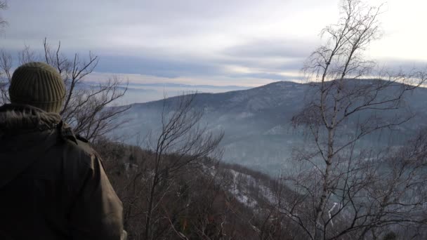 Man is watching winter landscape on mountain - Кадри, відео