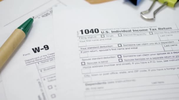 Clips de encuadernación con bolígrafo en W-9 y formulario de impuestos 1040
 - Metraje, vídeo