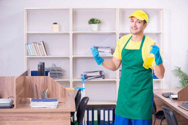 Young male contractor cleaning the office - Foto, Imagen