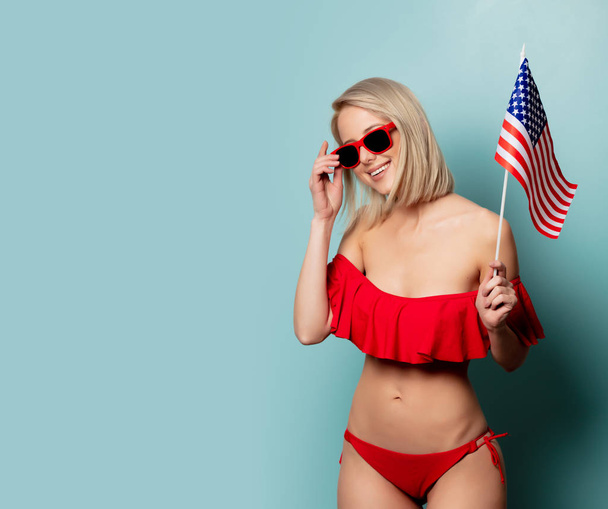 Beautiful blonde woman in bikini with USA flag  - Fotó, kép