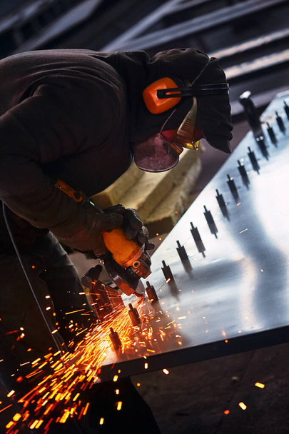 Heavy industry worker cutting steel with angle grinder - Photo, Image