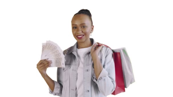Portré afro-amerikai nő bevásárló táskák és pénz rajongó fehér háttér stúdióban. Jean kabát - Felvétel, videó