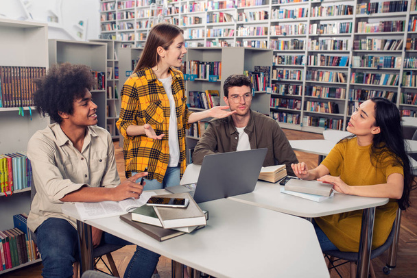 Universiteitsstudenten studeren samen in een bibliotheek. Concept van teamwork en voorbereiding - Foto, afbeelding