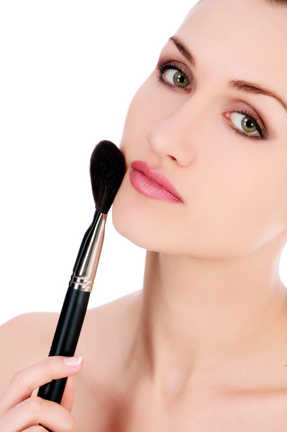nainen tekee meikkiä kasvot kosmeettisia harjalla
 - Valokuva, kuva