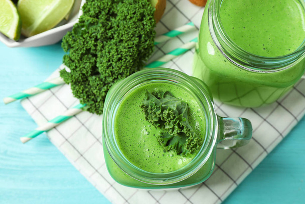 Tasty fresh kale smoothie on light blue table, flat lay - Фото, зображення
