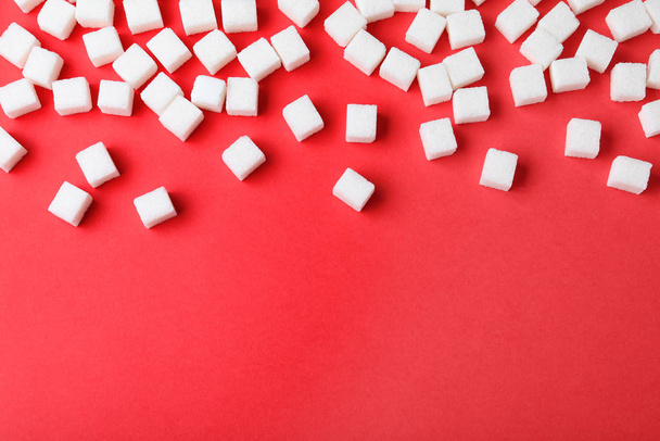 Refined sugar cubes on red background, top view. Space for text - Foto, afbeelding