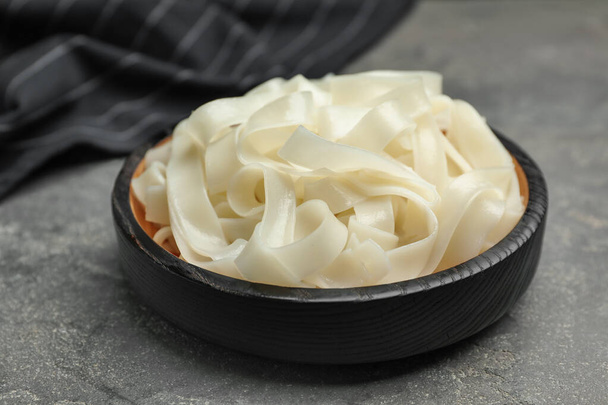Tasty cooked rice noodles on grey table, closeup - Photo, image