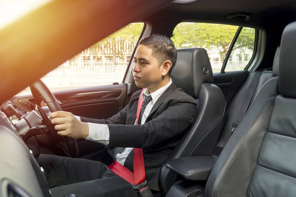 Young asian man wearing suit driving car - Fotó, kép