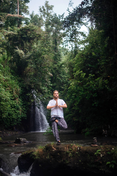 Prática de ioga e meditação na natureza. Homem praticando perto do rio
 - Foto, Imagem