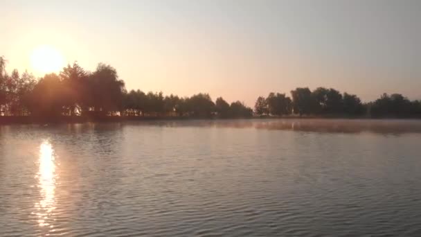 Wschód słońca nad jeziorem, odbicie słońca w wodzie. - Materiał filmowy, wideo