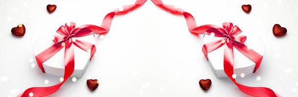 Tarjeta de San Valentín. Caja de regalo en forma de corazón con cinta roja aislada en blanco. Plantilla de mensaje romántico con espacio de copia
. - Foto, imagen