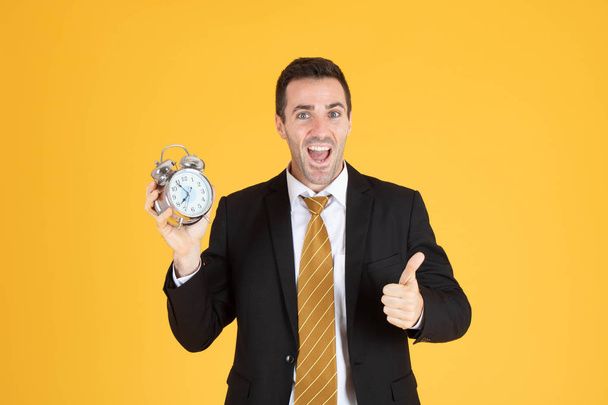 Porträt eines gutaussehenden Geschäftsmannes, der eine Uhr mit erhobenem Daumen hält  - Foto, Bild