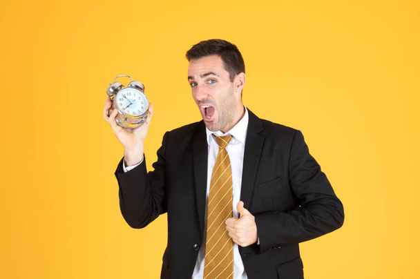 Porträt eines gutaussehenden Geschäftsmannes, der eine Uhr mit erhobenem Daumen hält  - Foto, Bild