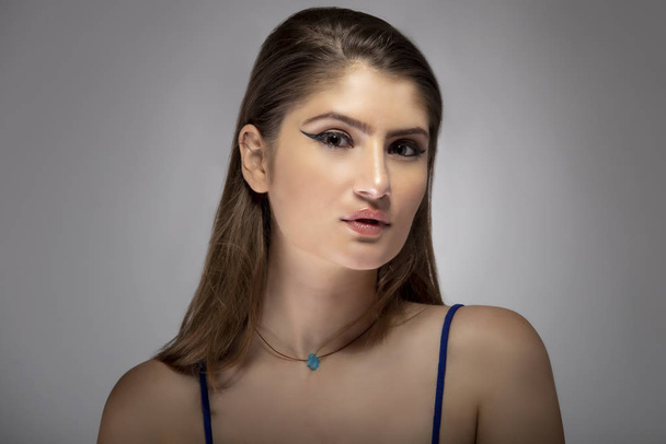 Krásná žena módní model headshot pózování s kosmetickou oční linky make-up. Zblízka portrét ukazuje přirozený a jednoduchý styl make-up - Fotografie, Obrázek