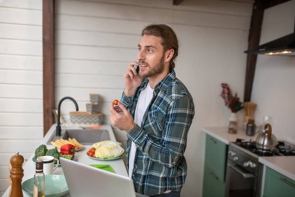 Egy férfi telefonál főzés közben. - Fotó, kép