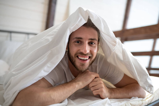 Jeune homme barbu s'amuser au lit le matin
 - Photo, image
