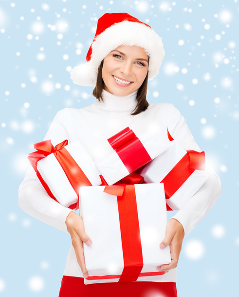 Woman in santa helper hat with many gift boxes - Foto, Imagen