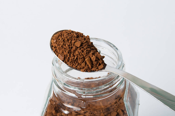 Instant coffee granules in a spoon, macro, on white background - Photo, Image