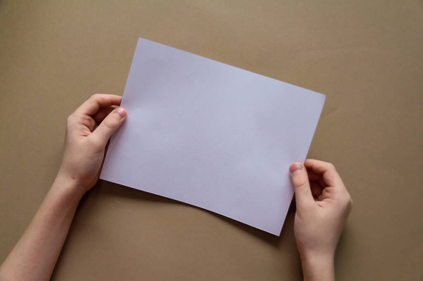 manos de los niños con nevo o marca de nacimiento mantener la lista blanca de papel papel artesanal fondo
 - Foto, Imagen