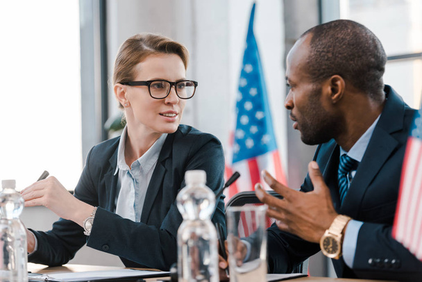 foco seletivo de diplomata atraente conversando com representante afro-americano
  - Foto, Imagem