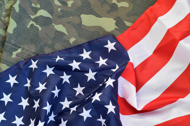 Прапор Сполучених Штатів Америки і складена військова уніфікована куртка. Військові символи Концептуальний фон для американських патріотичних свят - Фото, зображення