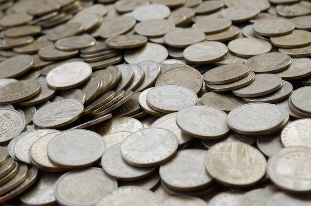 Большое количество блестящих украинских старых 1 гривны монет крупным планом. Концепция богатой жизни в Украине
 - Фото, изображение