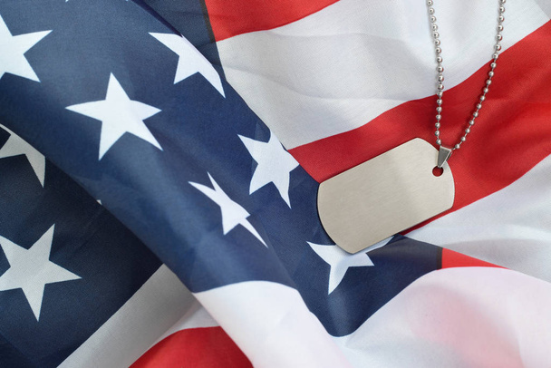 Ασημένιες στρατιωτικές χάντρες με ετικέτα σκύλου σε σημαία Ηνωμένων Πολιτειών ύφασμα - Φωτογραφία, εικόνα