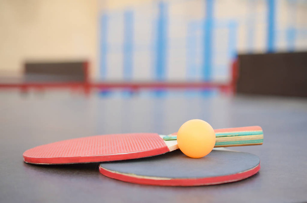 ütő és labda a ping-pong asztalon a szabadtéri sportpályán. Aktív sport- és testnevelési koncepció - Fotó, kép