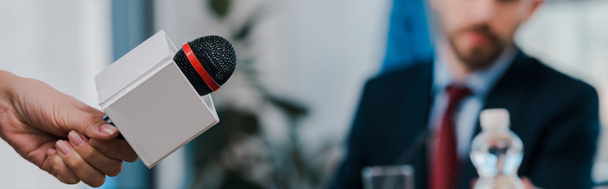 панорамний знімок журналіста, який тримає мікрофон біля дипломата
  - Фото, зображення