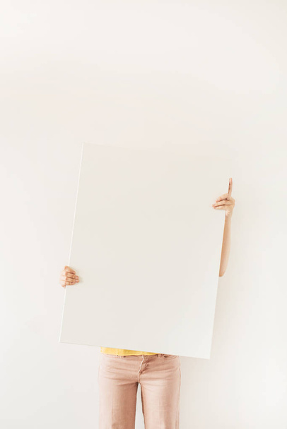 Blank canvas with empty mockup copy space in female hands. Minimal art concept. - Fotó, kép