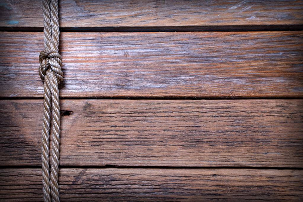 Ship rope knot on old wooden texture background - Photo, Image
