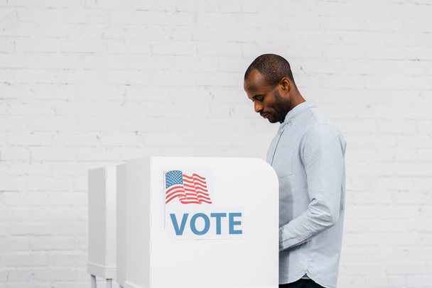 Αφροαμερικάνος πολίτης που ψηφίζει κοντά με γράμματα ψήφου  - Φωτογραφία, εικόνα