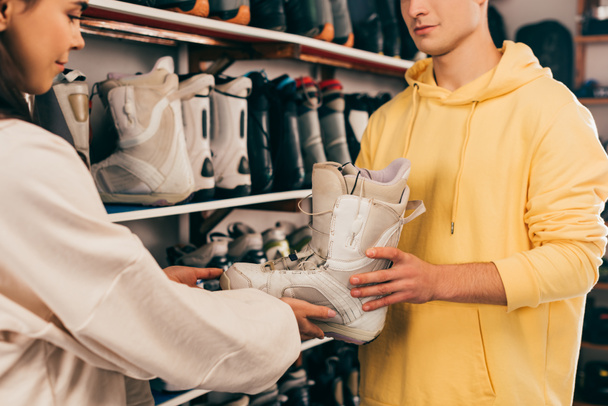 обрізаний вид працівника, що показує лижний черевик клієнту в ремонтному магазині
  - Фото, зображення