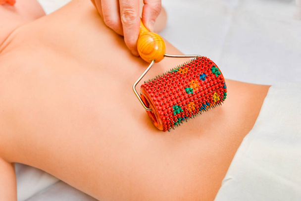 Massage healing roller with needles on the back of the patient - Zdjęcie, obraz
