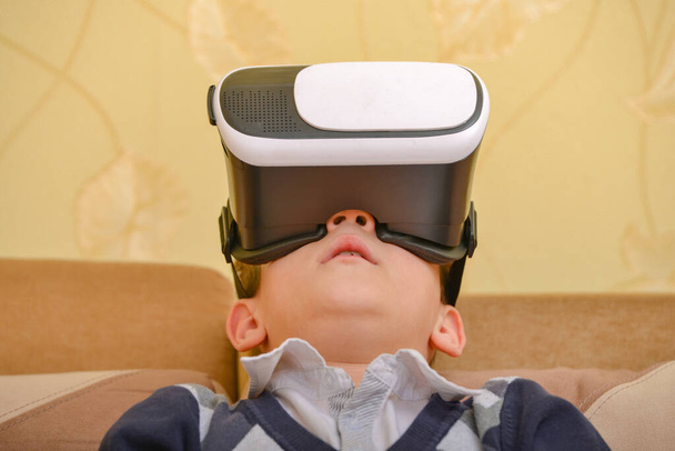 Il bambino guarda un video 3D attraverso gli occhiali e un PC
 - Foto, immagini