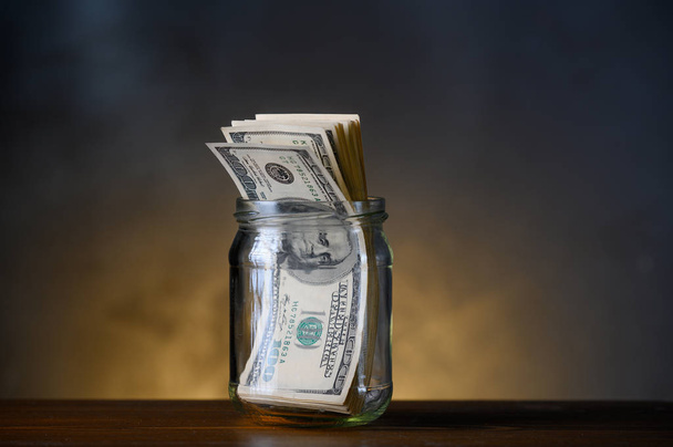 100 dollar bills in a glass jar. - Photo, Image