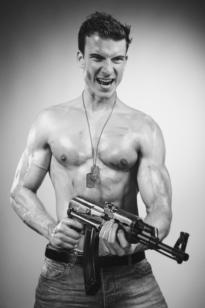 Power muscle man with AK-47 gun - 写真・画像