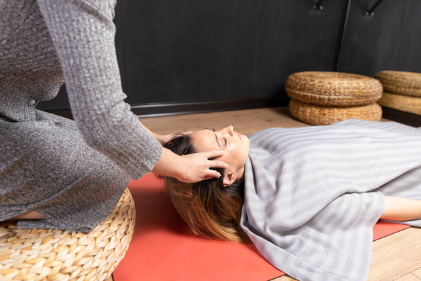 Terapia especial. O processo da cabeça relaxa a massagem. Mulher fazendo massagem pelas mãos
. - Foto, Imagem