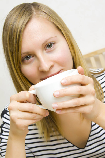 young woman holding cup of coffee - Fotó, kép