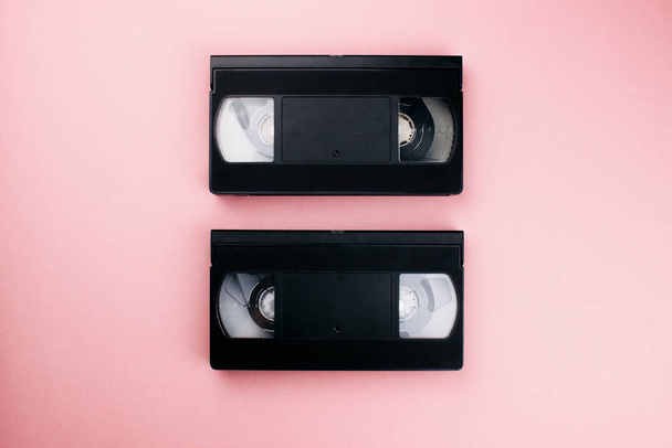 Retro-vhs-Videokassetten lagen flach auf buntem rosa Hintergrund. Kopierraum von oben. kreatives Modedesign im minimalen 80er-Jahre-Stil. Film, Film, Kinokonzept. Vorlage für das Web. Archivbild. - Foto, Bild