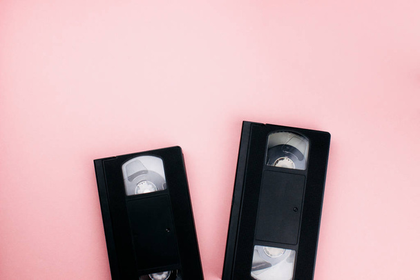 レトロVhsビデオカセットテープは、カラフルなピンクの背景に平らなレイアウト。トップビューのコピースペース。創造的なファッションデザインは、最小80代のスタイルで。映画、映画、映画のコンセプト。ウェブ用のテンプレート。ストックフォト. - 写真・画像